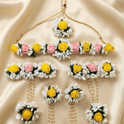 Handcrafted floral jewellery set with yellow and pink rose flowers including necklace, earrings, maang tikka and hand accessories for Haldi and Mehendi