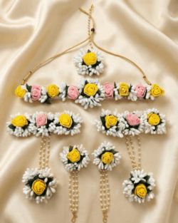 Handcrafted floral jewellery set with yellow and pink rose flowers including necklace, earrings, maang tikka and hand accessories for Haldi and Mehendi