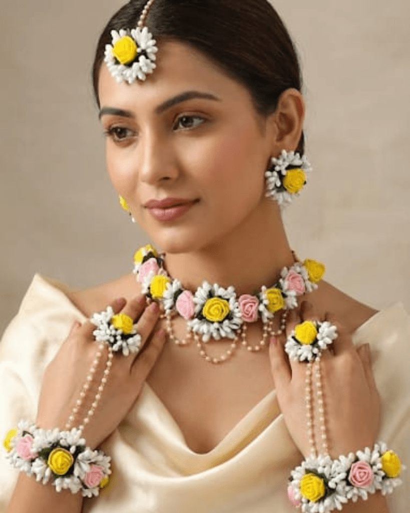 Handcrafted floral jewellery set with yellow and pink rose flowers including necklace, earrings, maang tikka and hand accessories for Haldi and Mehendi