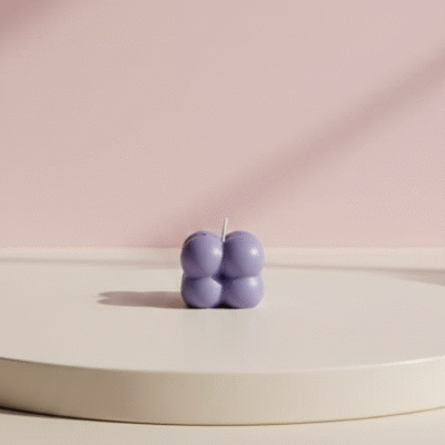 Peach wax candle with shimmering pink pearl bubble top in a low clear glass cup