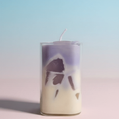 Dessert-style purple and white layered scented wax candle in a clear glass jar with embedded chunks