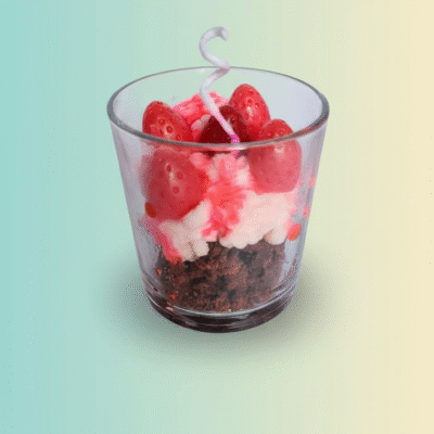 “Dessert-style scented wax candle in a glass cup with a red wax strawberry on top of a creamy base