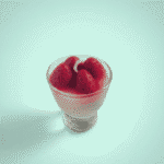Dessert-style wax candle with strawberries, chocolate base, cream wax, and lollipop-like wick in a glass jar