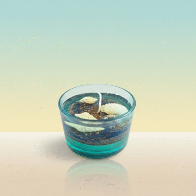 Ocean-themed blue gel wax candle with embedded seashells and cream wax layer in a glass jar