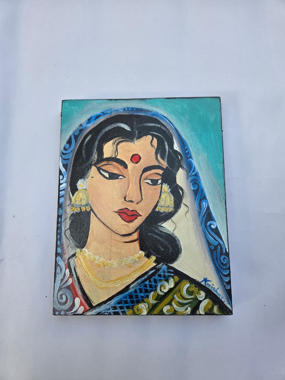 “Hand-painted wooden plaque with Kalighat-style portrait of Indian woman in saree”
