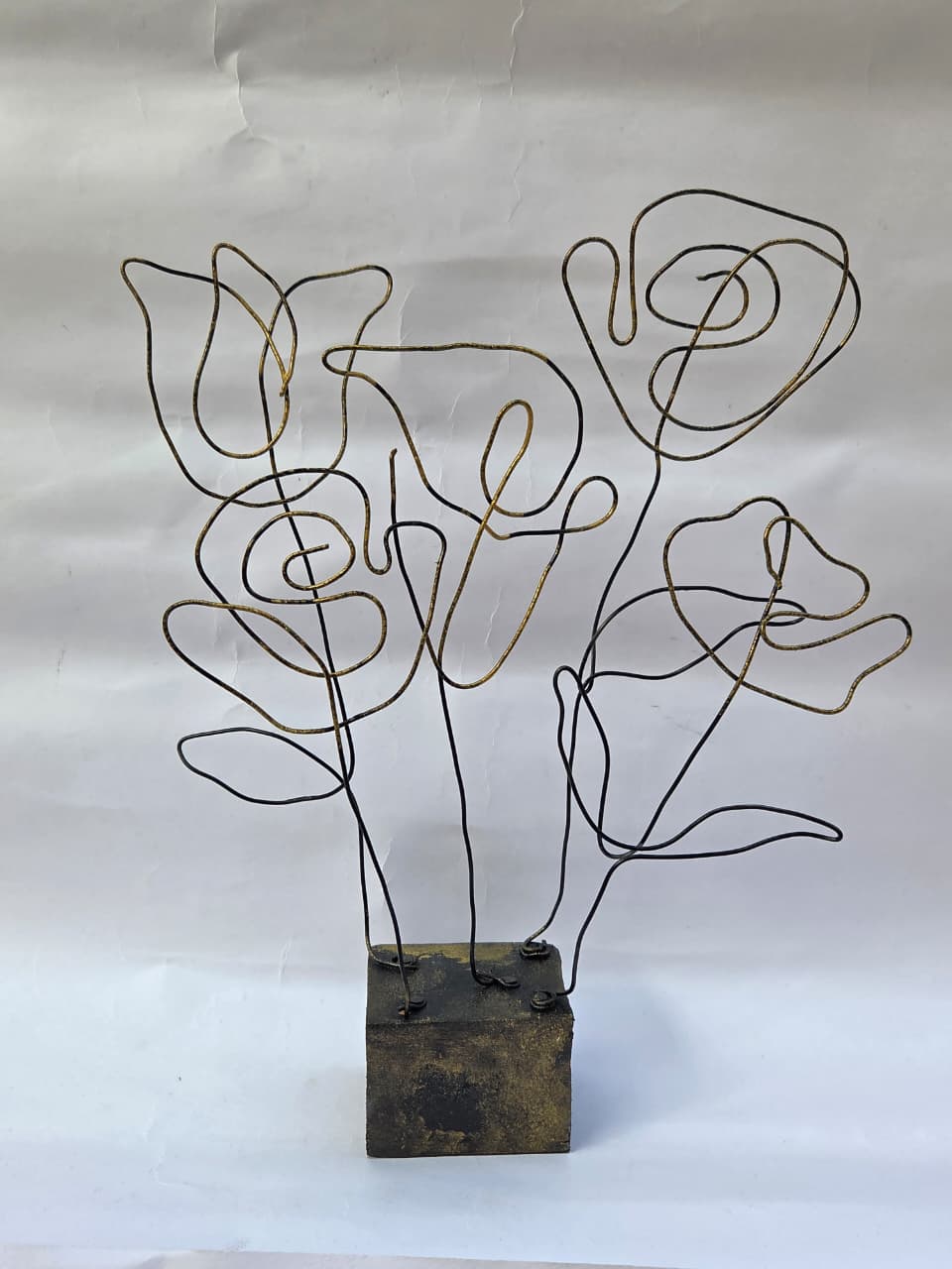 “Minimalist black and gold wire floral sculpture on distressed block base – abstract tabletop décor”