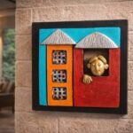 “Handmade terracotta wall art of a man looking out of a colorful window decorative piece”