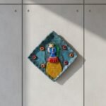 “Handmade terracotta woman wall art decorative plate with diamond shape and contemporary folk design”