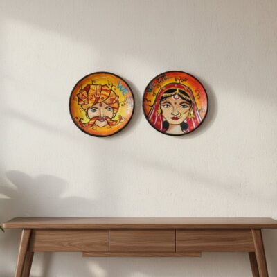 “Hand-painted Rajasthani bride and groom terracotta wall plates with orange-yellow gradient background”