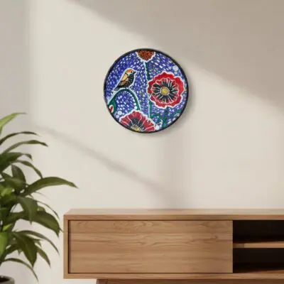 “Boho-style hand-painted terracotta wall plate with bird and red floral design on pointillism background”