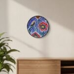 “Boho-style hand-painted terracotta wall plate with bird and red floral design on pointillism background”