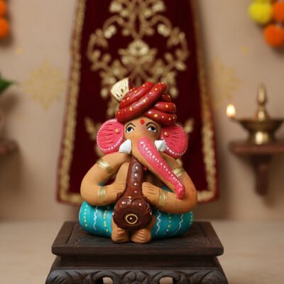 “Handcrafted Reading Ganesha clay idol on wooden chowki – colourful artisan statue for home décor”