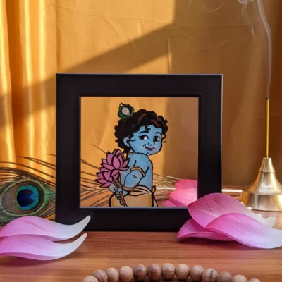 Handmade Bal Krishna glass painting in black frame holding lotus with spiritual aesthetic design