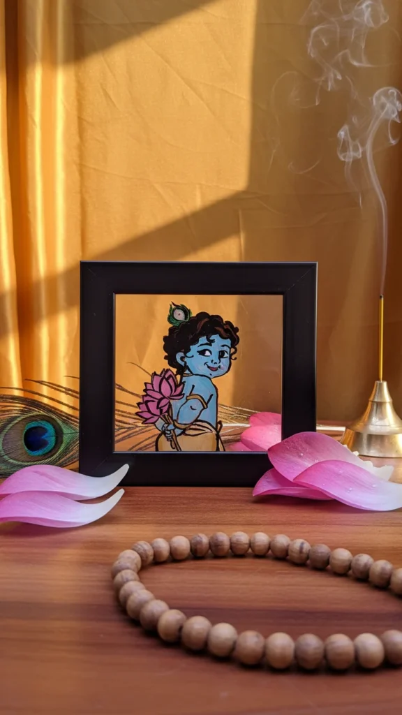 Handmade Bal Krishna glass painting in black frame holding lotus with spiritual aesthetic design