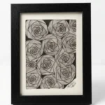 Handmade black and white floral line art framed wall decor on wooden floor with woven mat