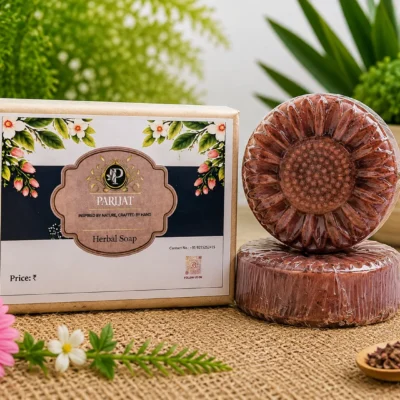 PARIJAT flower shaped herbal soap with two detailed floral brown-pink soap bars beside rectangular botanical packaging, displayed on a natural jute surface with flowers and greenery.