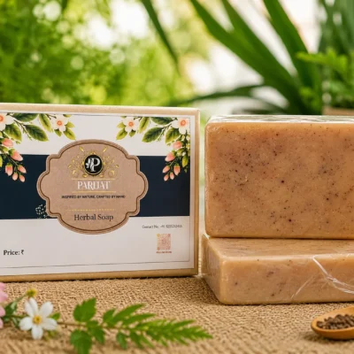 PARIJAT Herbal Soap with two natural beige speckled soap bars and rectangular floral packaging, displayed on a jute surface with fresh green leaves and flowers.