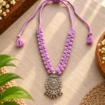 Handmade lilac twisted cord necklace with oxidized silver jhumka pendant on grey fabric